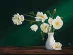 White poppy flowers in a vase on a wooden surface with a dark green background.